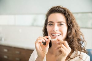 woman putting clear aligner in