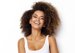 young woman smiling against white background