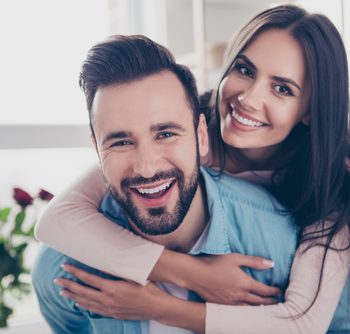young couple smiling and hugging