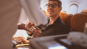 man on airplane talking to flight attendant